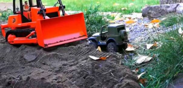 推土机用土埋掉越野车，这比拖拉机精巧多了