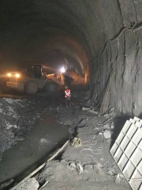 隧道内施工现场。装载机正在出两洞之间的人行横洞渣。