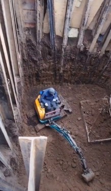 大挖掘机配合小挖掘机把土从坑里运出来