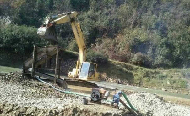 双峰县永丰街道松坪村河道内挖掘机声轰鸣，几台大型挖掘机在河道